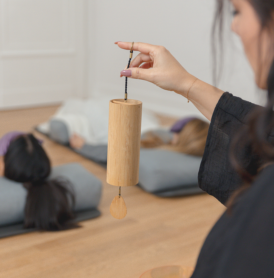 Person schlägt mit einem Klöppel an ein Klanginstrument. Person schlägt mit einem Klöppel an ein Klanginstrument.