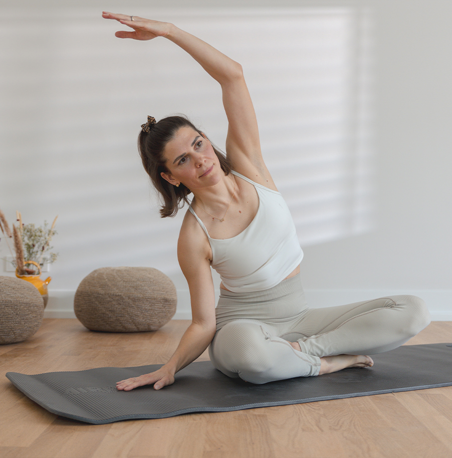 Person macht eine Dehnübung auf der Matte. Person macht eine Dehnübung auf der Matte.