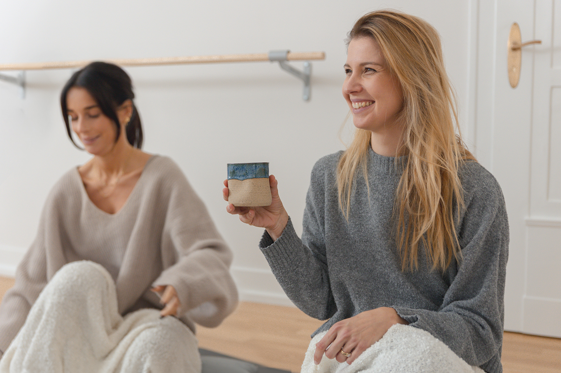 Zwei Personen sitzen und halten Becher. Zwei Personen sitzen und halten Becher.
