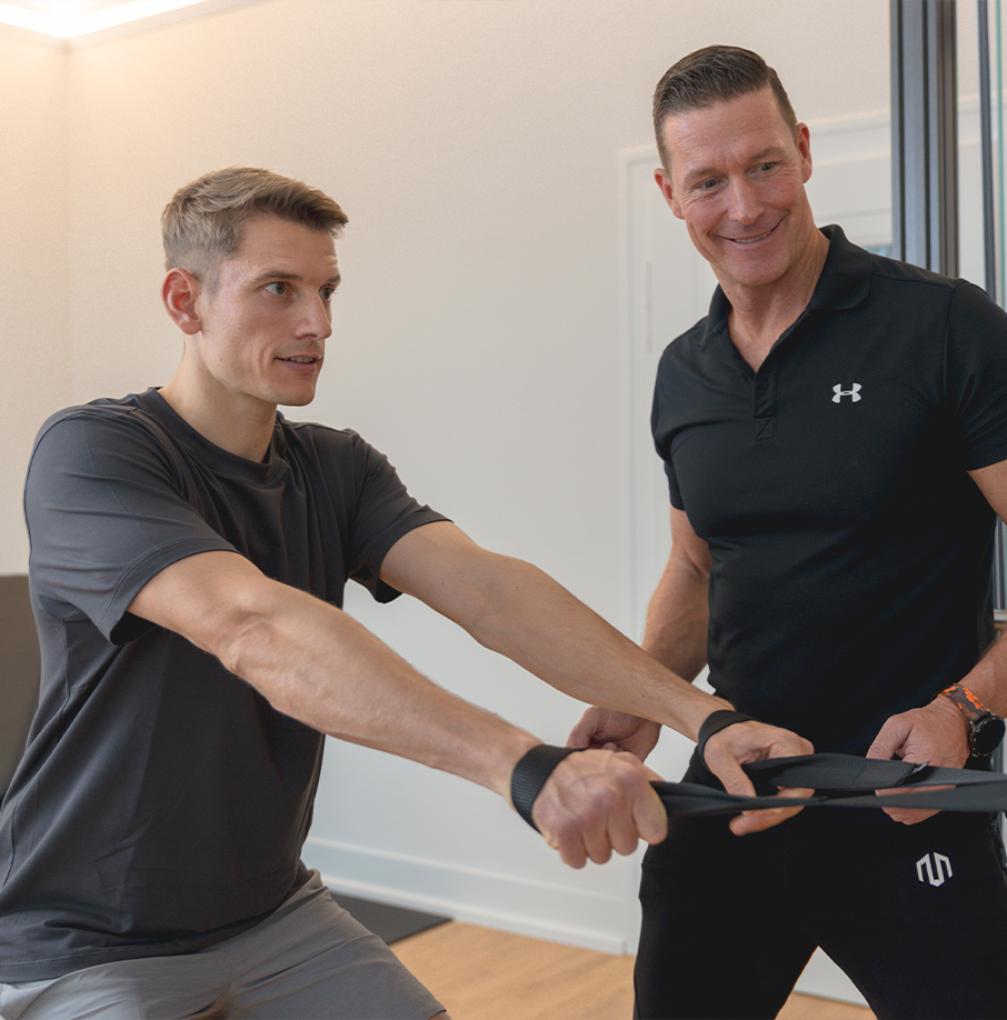 Zwei Personen trainieren mit einem Seilzuggerät. Zwei Personen trainieren mit einem Seilzuggerät.